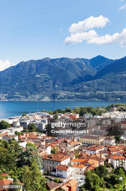 switzerland, ticino, locarno, city houses with lake maggiore and surrounding mountains in background - locarno stock pictures, royalty-free photos & images