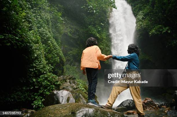 rear view of mother and daughter enjoying at a majestic waterfall - grand 8 stock pictures, royalty-free photos & images