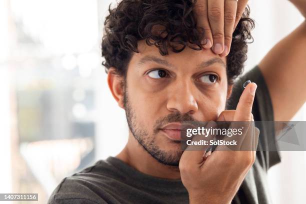 konzentration mit my contact linsen - hineinstecken stock-fotos und bilder