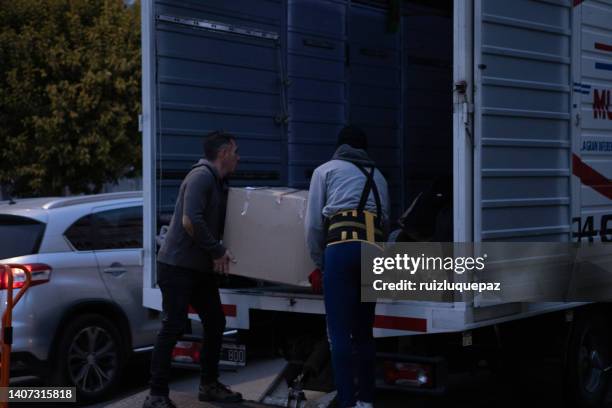 umzugsprozess. eigentümer und umzugspersonal verpacken, schützen und transportieren möbel und bewegliche sachen auf umzugswagen - hombres maduros stock-fotos und bilder