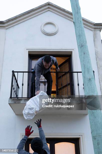 house moving process. owner and moving staff packing, protecting and transporting furniture and movables to moving truck - transporte de carga stock pictures, royalty-free photos & images