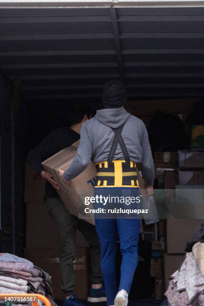 house moving process. owner and moving staff packing, protecting and transporting furniture and movables to moving truck - transporte de carga stock pictures, royalty-free photos & images