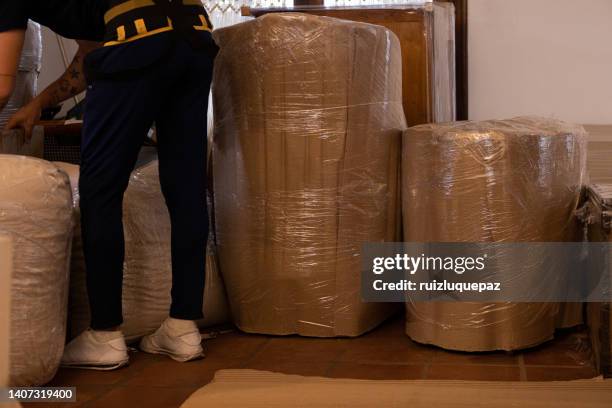 house moving process. owner and moving staff packing, protecting and transporting furniture and movables to moving truck - transporte de carga stock pictures, royalty-free photos & images