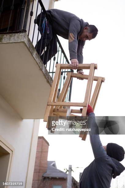 house moving process. owner and moving staff packing, protecting and transporting furniture and movables to moving truck - gente común y corriente stock pictures, royalty-free photos & images