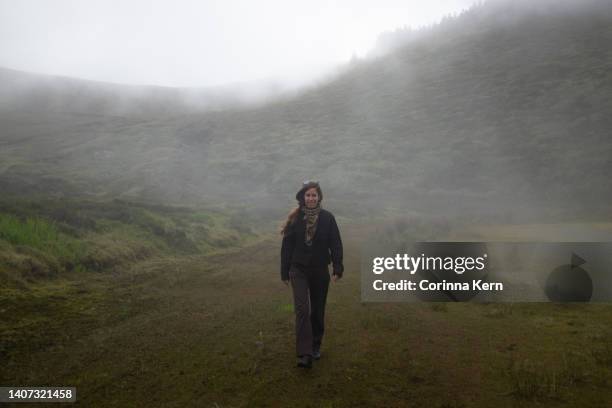 woman walking through foggy landscape - approaching imagens e fotografias de stock