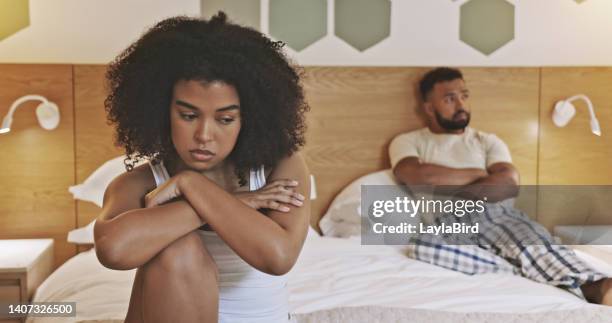 unhappy male and female having relationship problems and about to breakup. african american couple angry at each other in the morning and sitting in a bedroom. young upset couple avoiding each other - avoiding conflict stock pictures, royalty-free photos & images