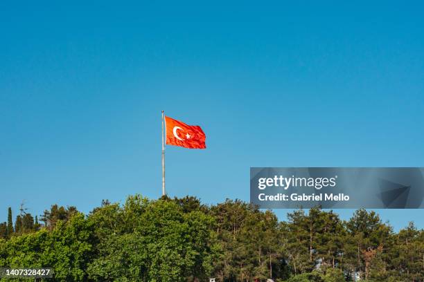 turkish flag flying against blue sky - bandera turca fotografías e imágenes de stock