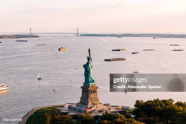 statue of liberty aerial view, new york city, usa - the sun sets behind the statue of liberty stock pictures, royalty-free photos & images