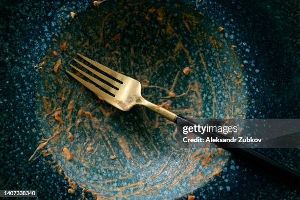 a dirty empty plate and fork on a wooden kitchen or dining table. cutlery is used, symbolizing the end of lunch or dinner. - cleaning after party stock pictures, royalty-free photos & images