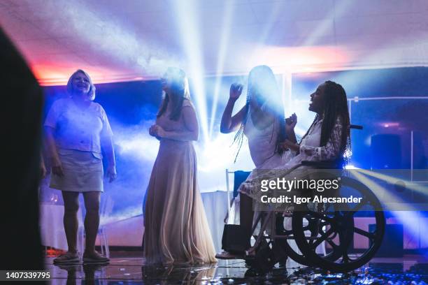 wheelchair woman enjoying disco with friends - disco dancing stock pictures, royalty-free photos & images