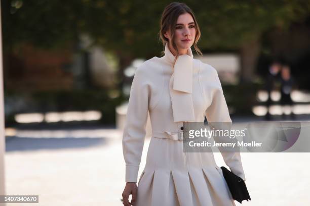 Zita d'Hauteville seen wearing a white creme scarf from Dior, a matching white creme jacket, a matching white creme pleated / belted short skirt, a...