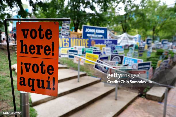 Campaign signs compete for space during the first day of early voting in the state outside the Silver Spring Civic Building at Veterans Plaza on July...