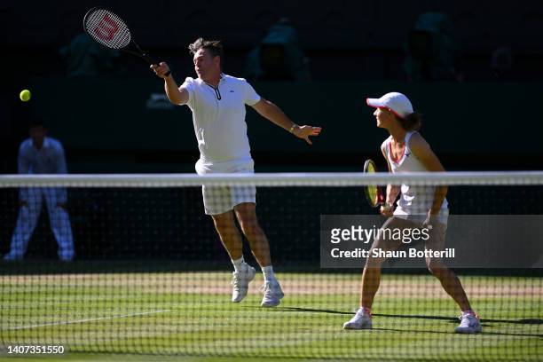 Todd Woodbridge of Australia plays a forehand as partner Cara Black of Zimbabwe looks on against Mansour Bahrami of France and Conchita Martinez of...