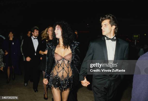 Cher in a sheer dress holds hands with Rob Camiletti in the United States, September 1987.