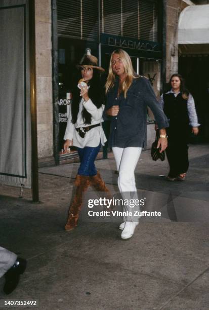 Cher and Gregg Allman walk down the street together in the United States, circa 1977.