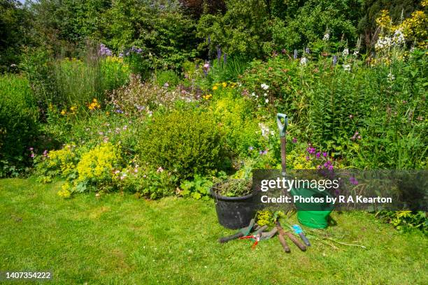 garden tools beside a mixed border in an english country garden - flower bucket stock pictures, royalty-free photos & images