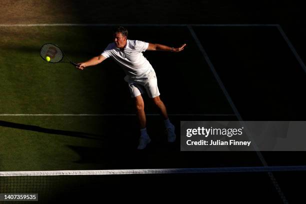 Todd Woodbridge of Australia plays a forehand with partner Cara Black of Zimbabwe against Mansour Bahrami of France and Conchita Martinez of Spain...