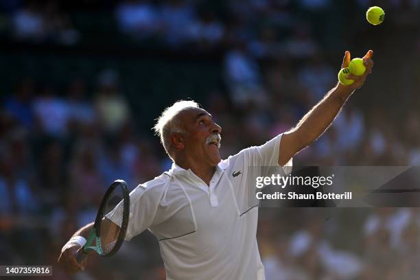 Mansour Bahrami of Iran serves as partner Conchita Martinez of Spain looks on against Todd Woodbridge of Australia and Cara Black of Zimbabwe during...