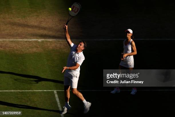 Todd Woodbridge of Australia plays an overhead shot with partner Cara Black of Zimbabwe looking on against Mansour Bahrami of France and Conchita...