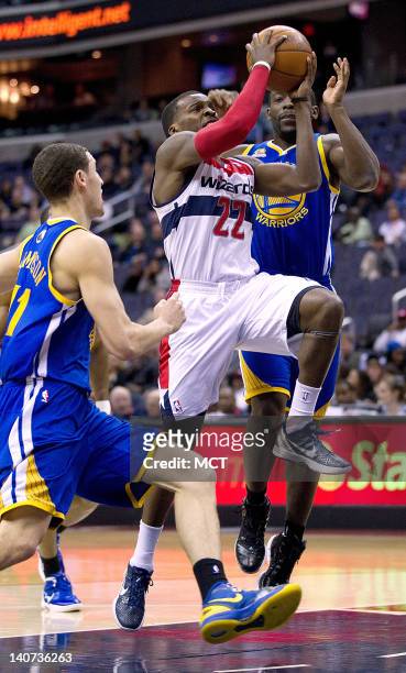 Washington Wizards guard Shelvin Mack drives to the basket between Golden State Warriors guard Klay Thompson , left and guard Charles Jenkins during...