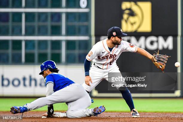 Melendez of the Kansas City Royals slides safely past Jose Altuve of the Houston Astros in the third inning at Minute Maid Park on July 07, 2022 in...