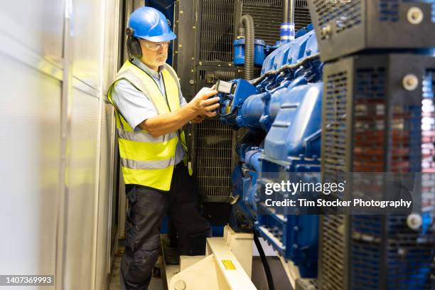 a maintenance engineer is inspecting and repairing a diesel generator - gerador - fotografias e filmes do acervo