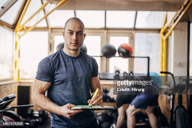 male fitness instructor in gym - personal trainer stock pictures, royalty-free photos & images