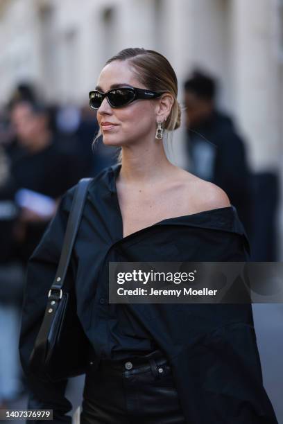 Chiara Ferragni seen wearing silver pendant earrings from Balenciaga, black sunglasses from Balenciaga, a black oversized shirt, a black leather...