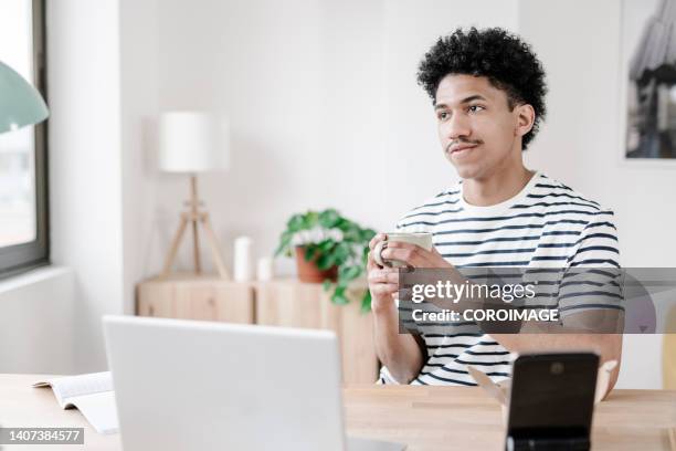 young man having coffee after lunch at home - coffee moustache stock pictures, royalty-free photos & images