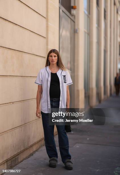 Veronika Heilbrunner seen wearing gold pearl earrings, gold pendant necklace, a black ripped t-shirt, a white short sleeves buttoned baseball shirt,...
