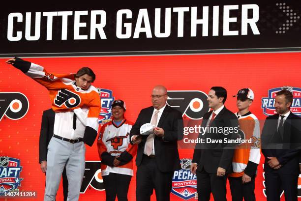 Cutter Gauthier puts on a jersey onstage after being selected fifth overall by the Philadelphia Flyers during the first round of the 2022 Upper Deck...