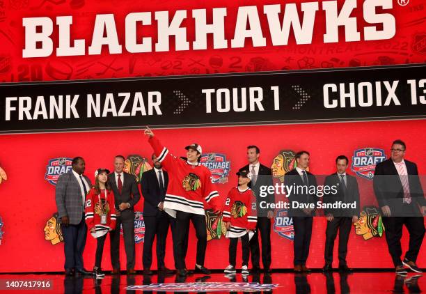 Frank Nazar points to the seats while onstage with team personnel after being selected 13th overall by the Chicago Blackhawks during the first round...