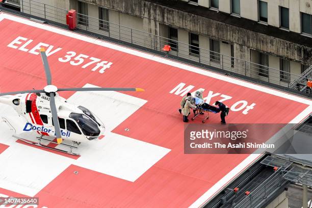 In this aerial image, former Prime Minister Shinzo Abe is on a stretcher to a helicopter after being shot in front of Yamatosaidaiji Station on July...