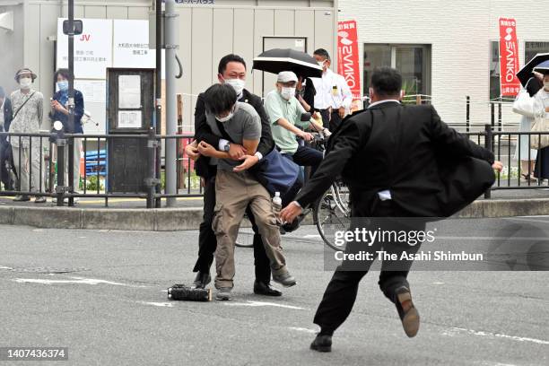 Security police tackle to arrest a suspect who is believed to shoot former Prime Minister Shinzo Abe in front of Yamatosaidaiji Station on July 8,...