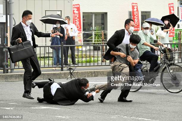 Security police tackle to arrest a suspect who is believed to shoot former Prime Minister Shinzo Abe in front of Yamatosaidaiji Station on July 8,...