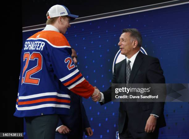 Reid Schaefer shakes hands with general manager Ken Holland after being selected 32nd overall by the Edmonton Oilers during the first round of the...