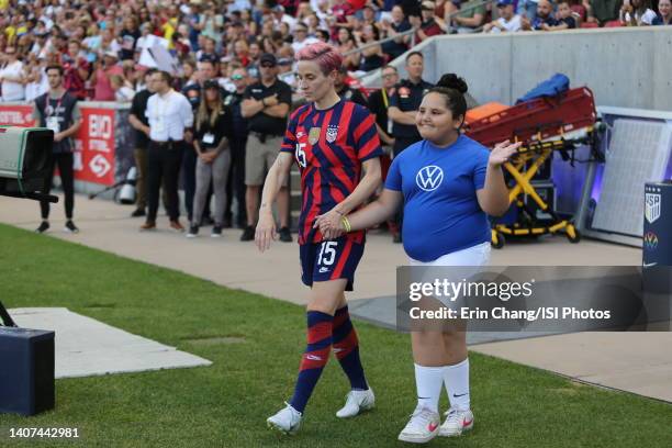 Megan Rapinoe of the United States walks out for the national anthem with a player escort before a game between Colombia and USWNT at Rio Tinto...