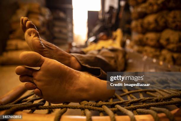 mature man sleeping on the cot - indian female feet foto e immagini stock