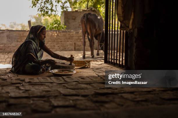 side profile of a mid adult woman grinding wheat into a grind stone - woman sleep stockfoto's en -beelden