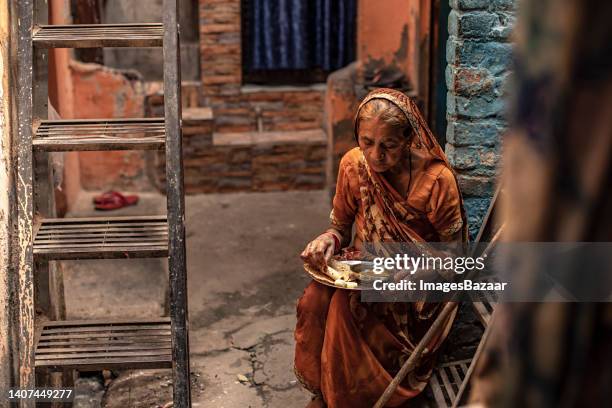 senior woman eating food - indian slums fotografías e imágenes de stock