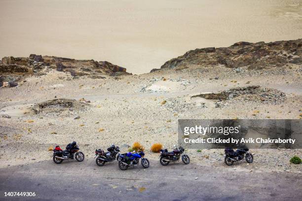 group of motorcycles takes a break in barren deserts of himalayas, india - lamayuru stock pictures, royalty-free photos & images