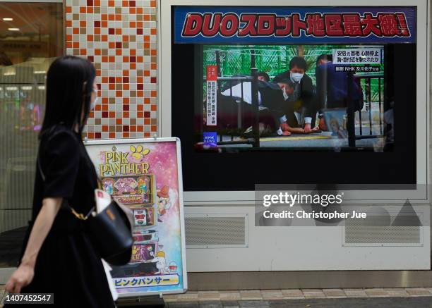 Woman looks at a screen broadcasting the news of Japan's former Prime Minister Shinzo Abe being shot while campaigning in Nara, Japan on July 08,...