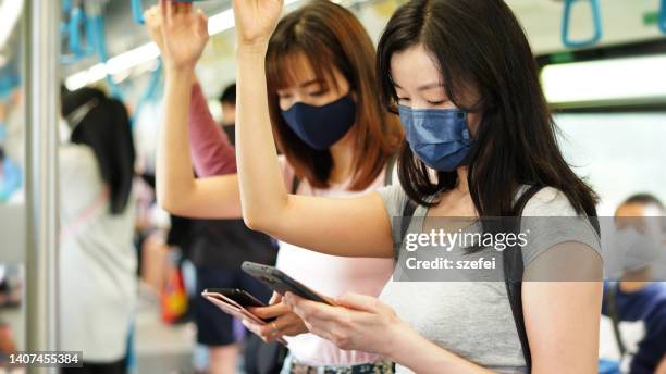 asian woman using phone in commuter - commuter train stock pictures, royalty-free photos & images