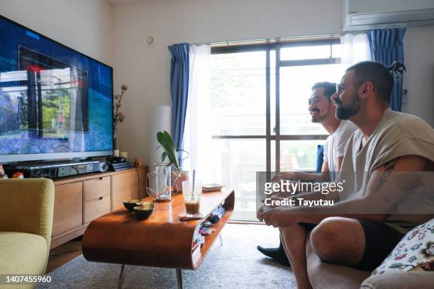 two men playing games at home. - reality tv stock-fotos und bilder