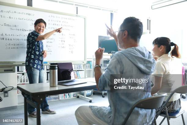 sign language instructor demonstrating to a class of sign language learners - deafness stock pictures, royalty-free photos & images