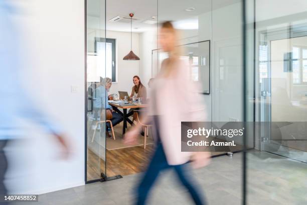 indoor shot of business people walking and moving around bright modern office - porta de tela imagens e fotografias de stock