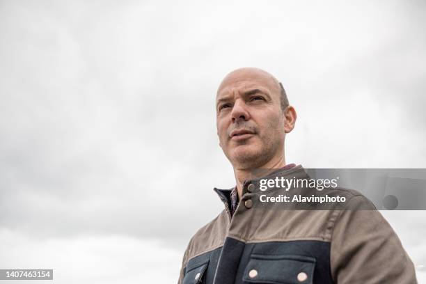 portrait of a bald man with a cloudy sky background - one mature man only stock pictures, royalty-free photos & images