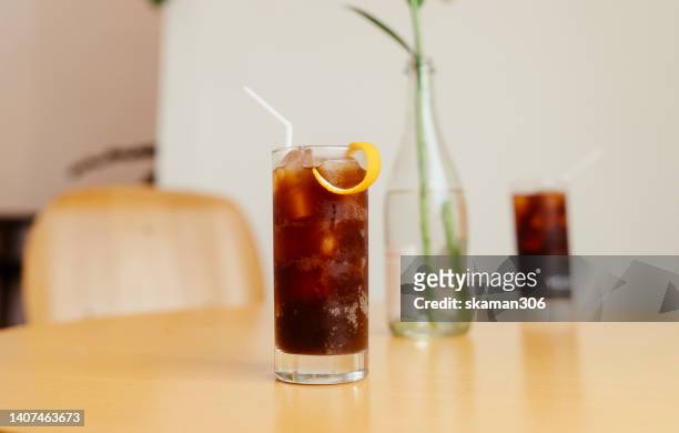 selective focus ice americano coffee on wooden table and decoration beautiful flower cafe and copy space - mokka eis stock-fotos und bilder