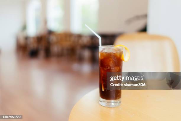 selective focus ice americano coffee on wooden table and decoration beautiful flower cafe and copy space - coffee drink - fotografias e filmes do acervo