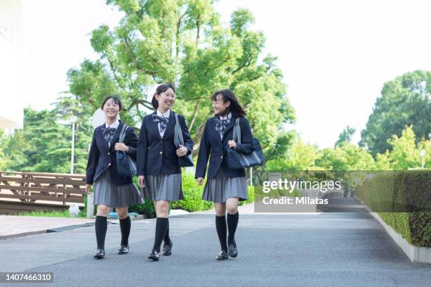 high school girl walking while having a conversation - female high school student stock pictures, royalty-free photos & images